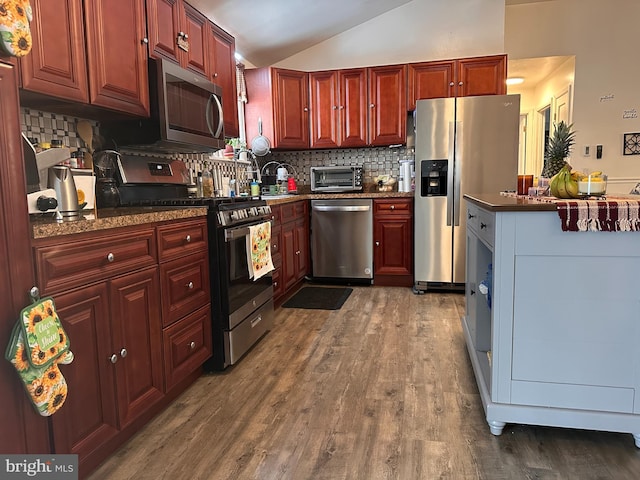 kitchen featuring tasteful backsplash, lofted ceiling, stainless steel appliances, and dark hardwood / wood-style flooring