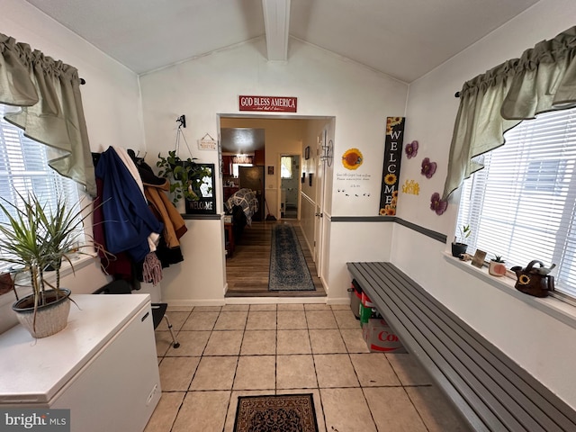 interior space with vaulted ceiling with beams and light tile patterned floors