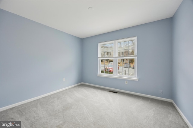 unfurnished room featuring light colored carpet