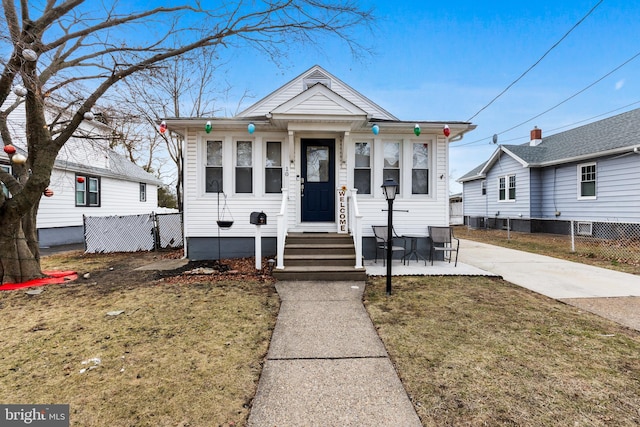 bungalow-style house featuring cooling unit and a front lawn