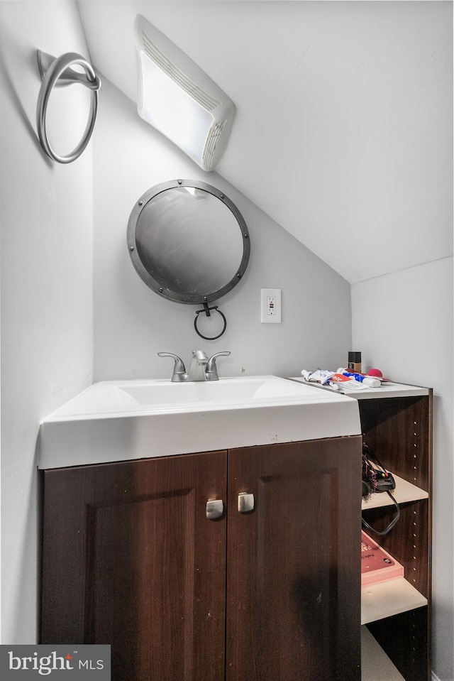 bathroom featuring vanity and lofted ceiling