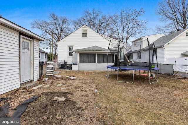 view of yard with a sunroom and a trampoline