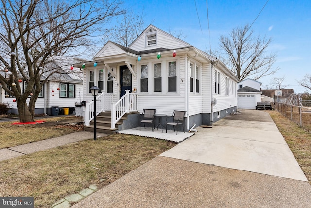 bungalow-style house with a garage, an outdoor structure, and a front yard