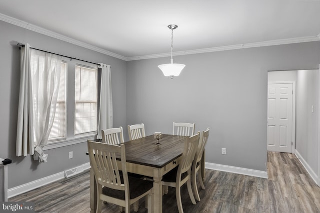 dining space featuring ornamental molding and dark hardwood / wood-style floors