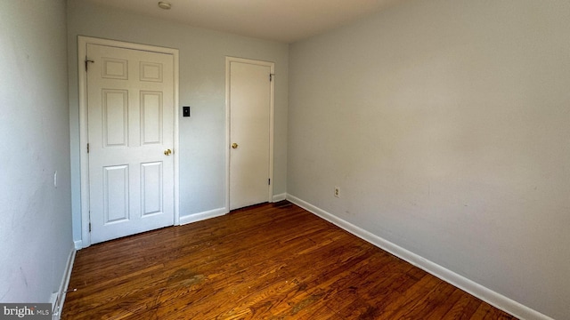 unfurnished bedroom with dark wood-type flooring