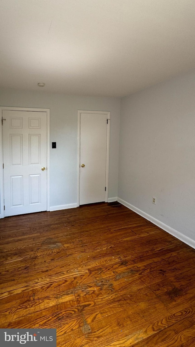 unfurnished room featuring dark wood-type flooring