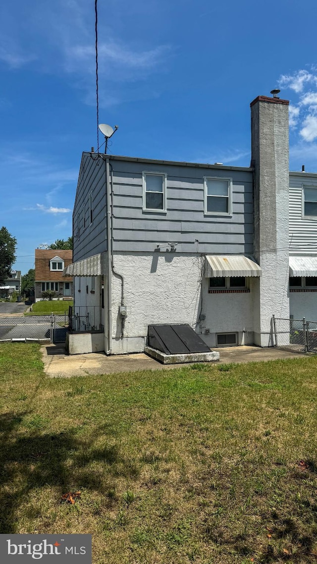 rear view of property with a lawn