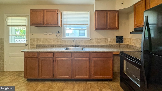 kitchen with backsplash, sink, exhaust hood, and black appliances