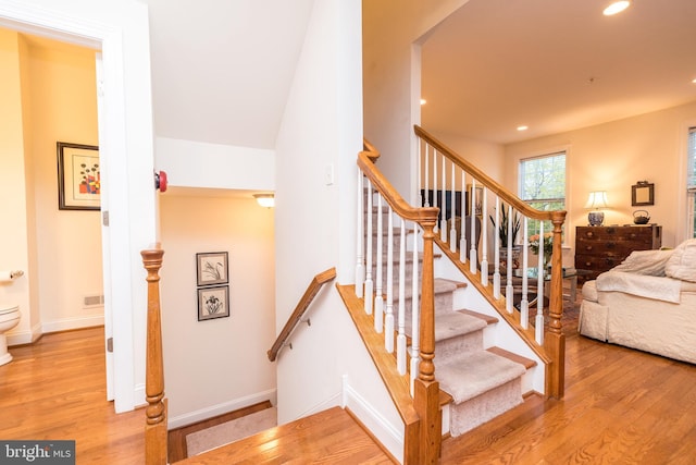 staircase with hardwood / wood-style floors