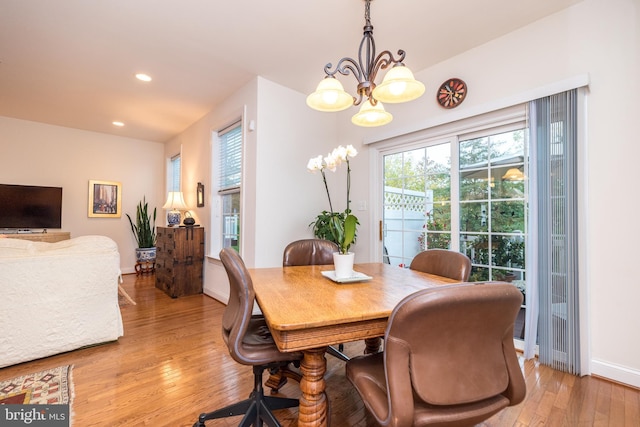 dining area with a chandelier and light hardwood / wood-style flooring