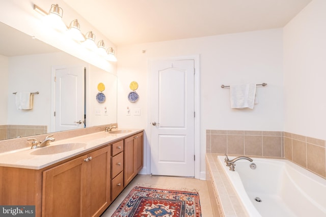 bathroom featuring a relaxing tiled tub, vanity, and tile patterned flooring