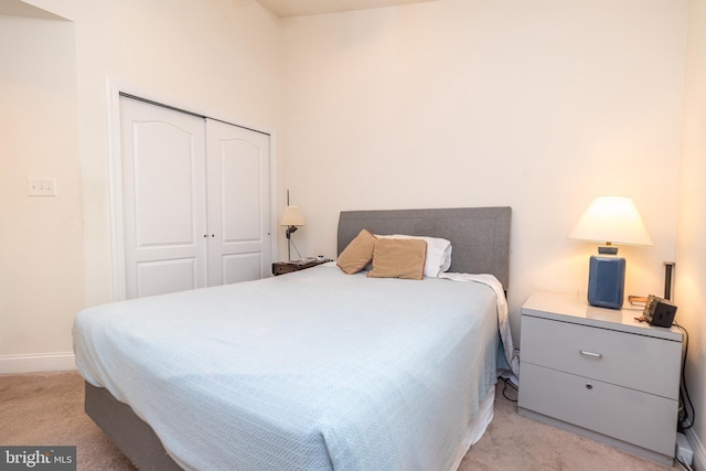 bedroom featuring light colored carpet and a closet