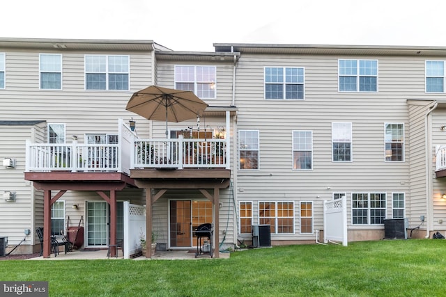 rear view of property featuring a wooden deck, cooling unit, a patio area, and a lawn