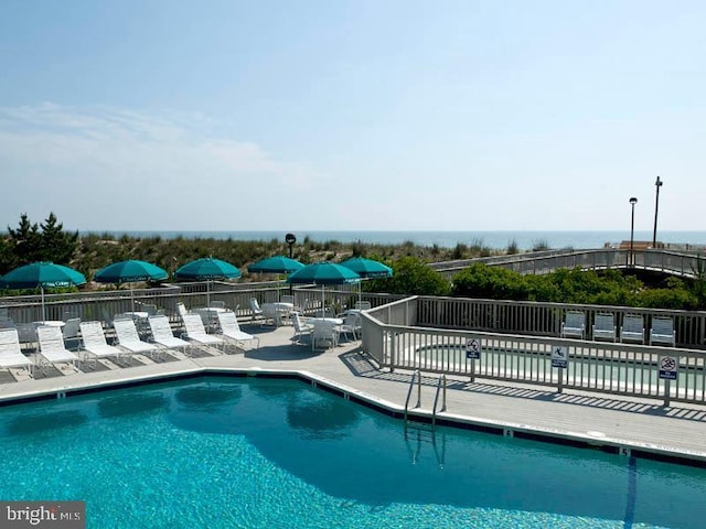 view of pool featuring a patio and a water view