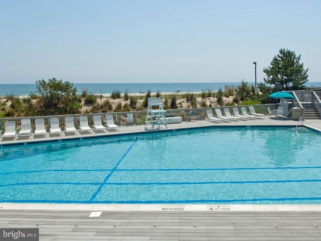 view of swimming pool featuring a water view