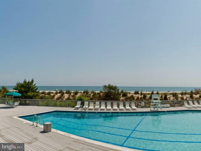 view of swimming pool with a patio and a water view