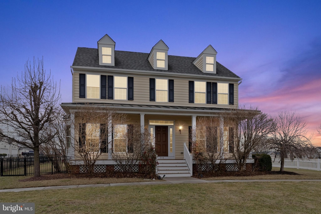 view of front of home with a porch and a lawn