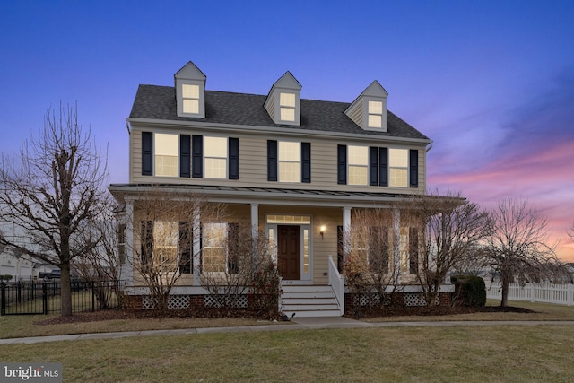 view of front of home with a porch and a lawn