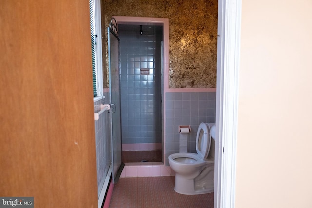 bathroom featuring tile walls, tile patterned floors, toilet, and tiled shower