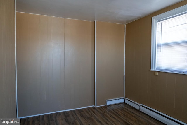 interior space with dark hardwood / wood-style flooring and a baseboard heating unit