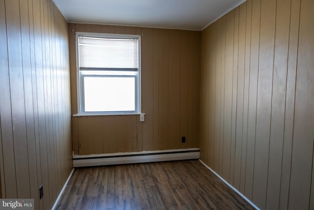 spare room featuring dark hardwood / wood-style flooring and a baseboard heating unit