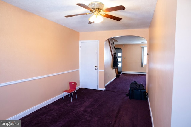 corridor featuring dark colored carpet and baseboard heating