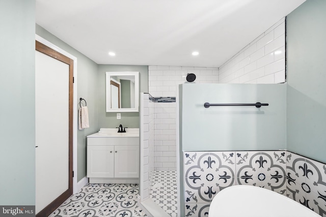 bathroom with tile patterned floors, vanity, and a tile shower