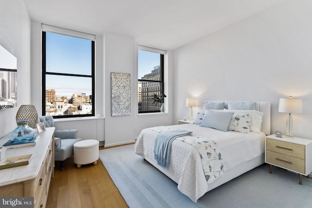 bedroom with hardwood / wood-style floors and multiple windows