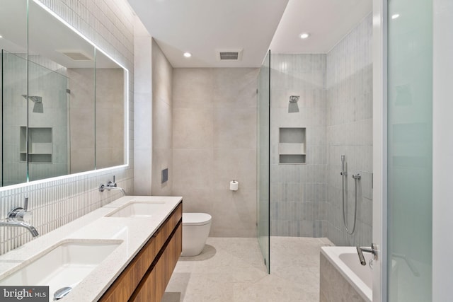 full bathroom featuring tile walls, vanity, plus walk in shower, tile patterned floors, and toilet