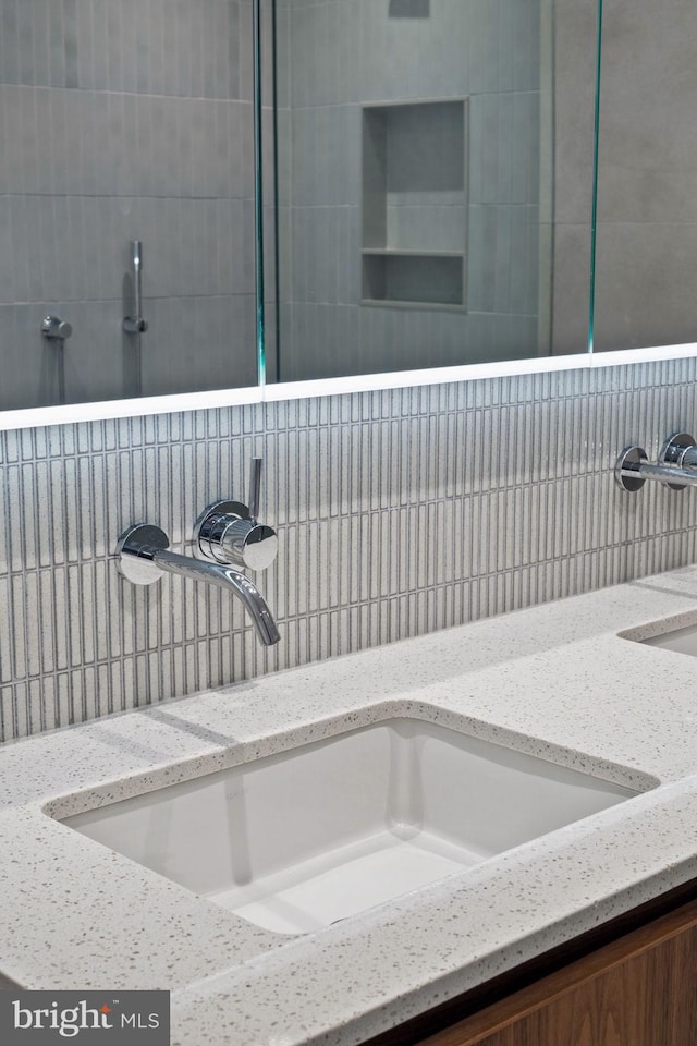 bathroom featuring sink and a tile shower