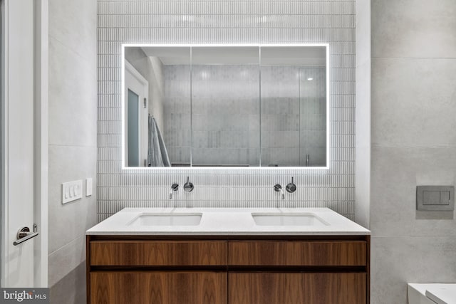 bathroom with vanity and tile walls