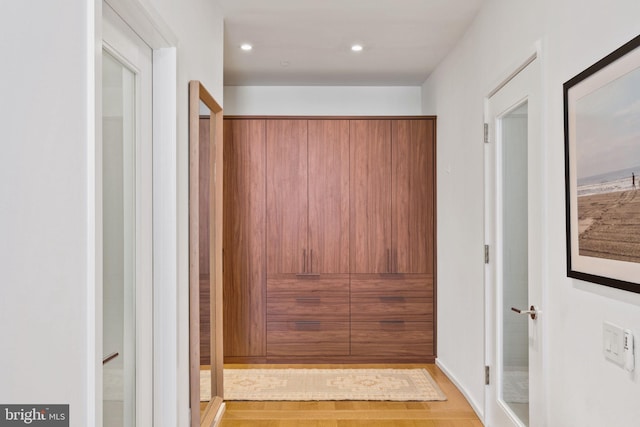 corridor with light hardwood / wood-style flooring