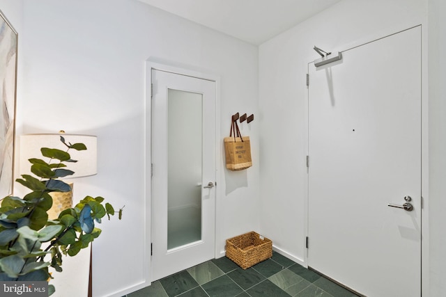 entryway featuring dark tile patterned floors