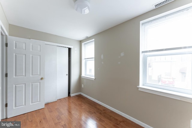 unfurnished bedroom with hardwood / wood-style flooring and a closet