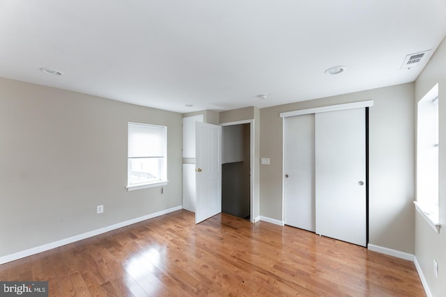 unfurnished bedroom featuring light hardwood / wood-style floors and a closet