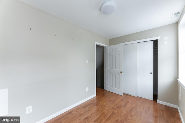 unfurnished bedroom featuring light hardwood / wood-style floors and a closet