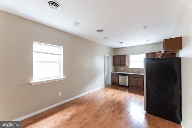 kitchen with sink, light wood-type flooring, and appliances with stainless steel finishes