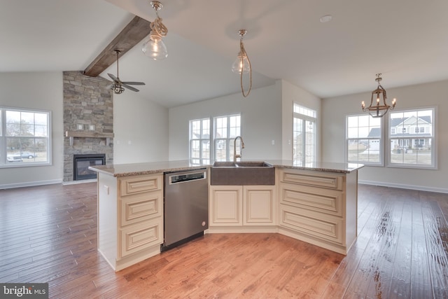 kitchen with stainless steel dishwasher, sink, light hardwood / wood-style floors, and an island with sink