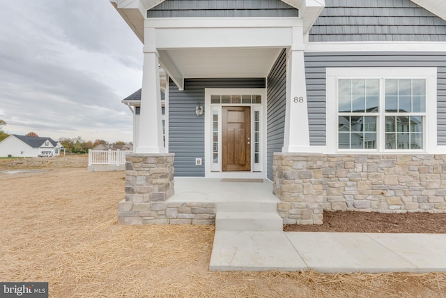 view of exterior entry featuring covered porch