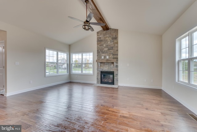 unfurnished living room with vaulted ceiling with beams, light hardwood / wood-style flooring, a fireplace, and ceiling fan