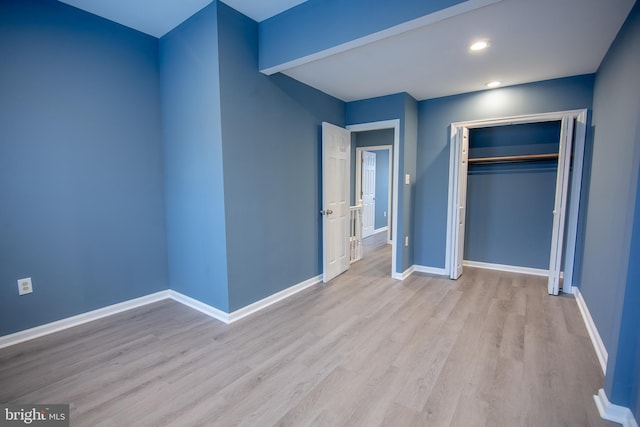 unfurnished bedroom featuring a closet and light hardwood / wood-style flooring