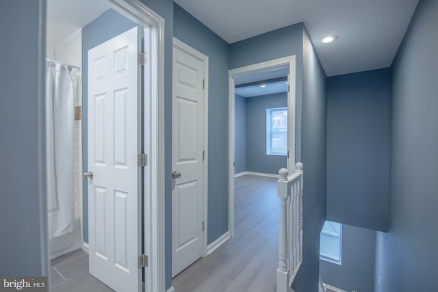 corridor with light hardwood / wood-style flooring