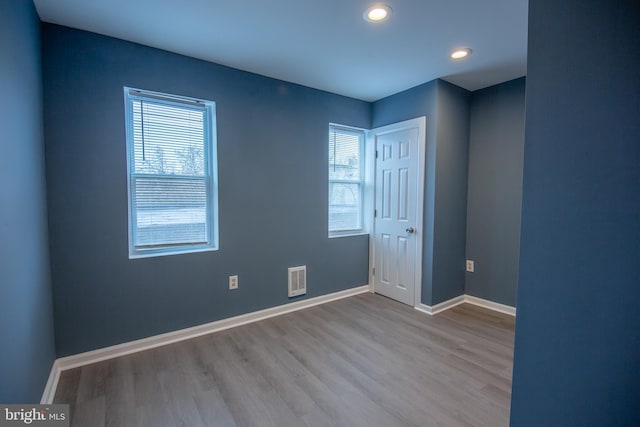 spare room featuring light hardwood / wood-style flooring and a wealth of natural light