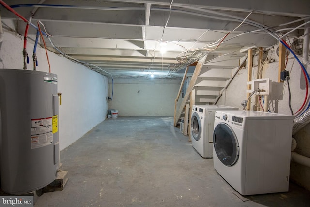 basement featuring electric water heater and washer and dryer