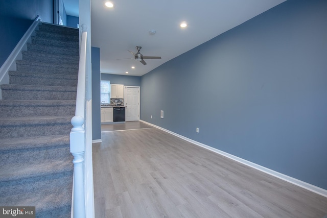 unfurnished living room featuring ceiling fan and light wood-type flooring