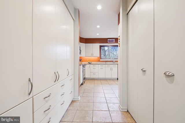 hall featuring a sink and recessed lighting