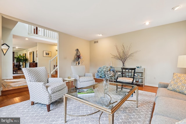 living room with recessed lighting, wood finished floors, visible vents, baseboards, and stairway