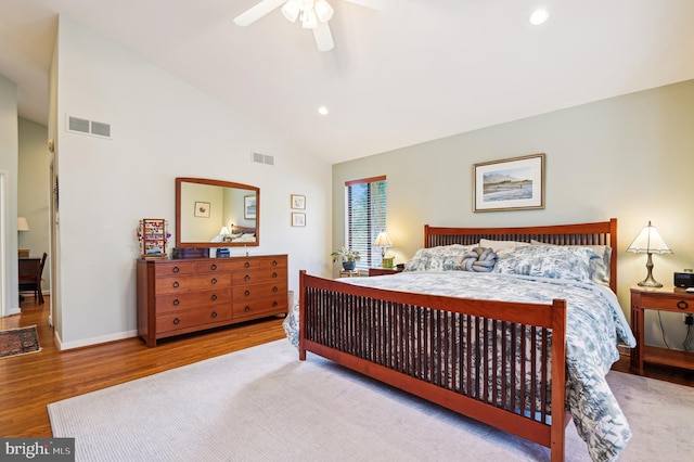 bedroom featuring lofted ceiling, visible vents, baseboards, and wood finished floors