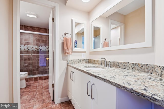 full bath featuring baseboards, a shower stall, toilet, and vanity