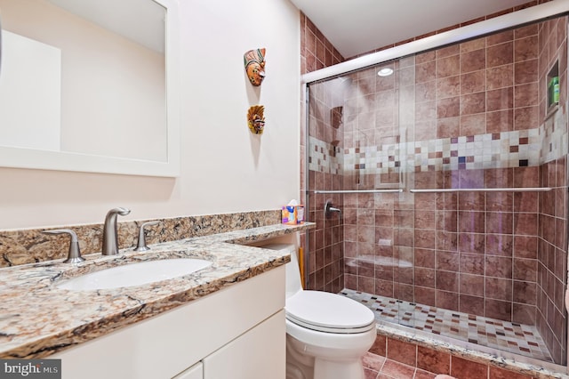 bathroom featuring a stall shower, vanity, and toilet